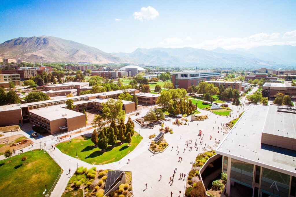 Aerial view of many people walking on pathways around a large outdoor campus.