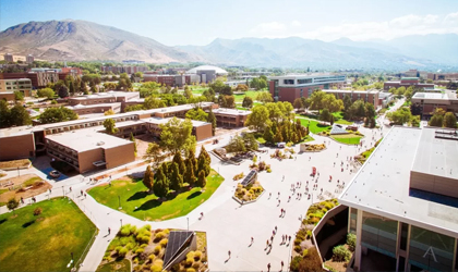 Aerial view of many people walking on pathways around a large outdoor campus.
