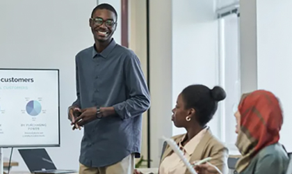 Data analyst proudly presenting a report to a group in a conference room.