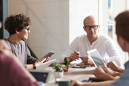 Programmers and managers planning a new project around a table in an office.